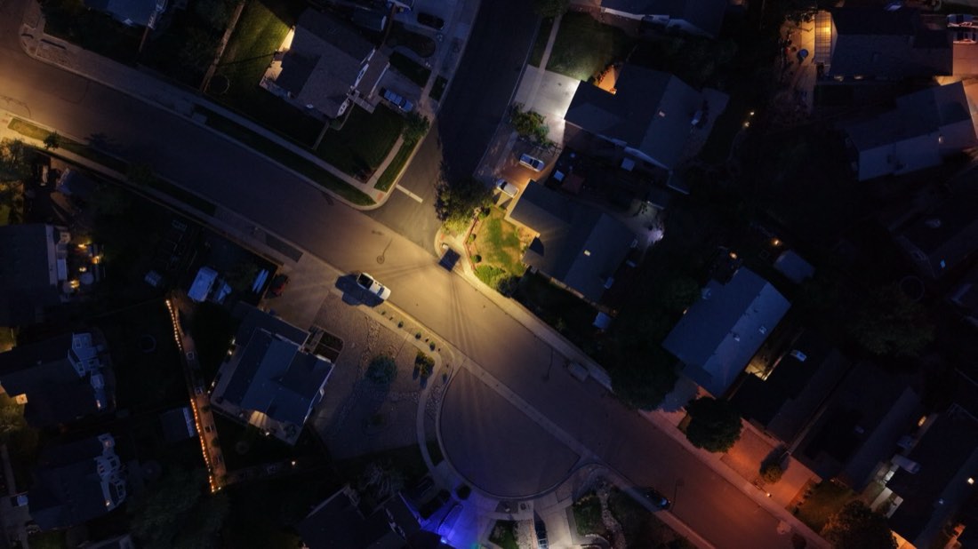 Top-down nadir aerial of a lit intersection at night