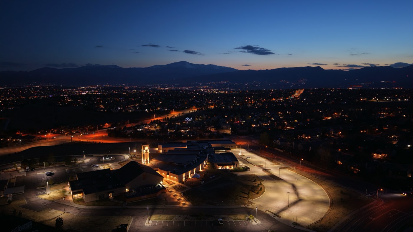 Dusk aerial of an illuminated municipal complex